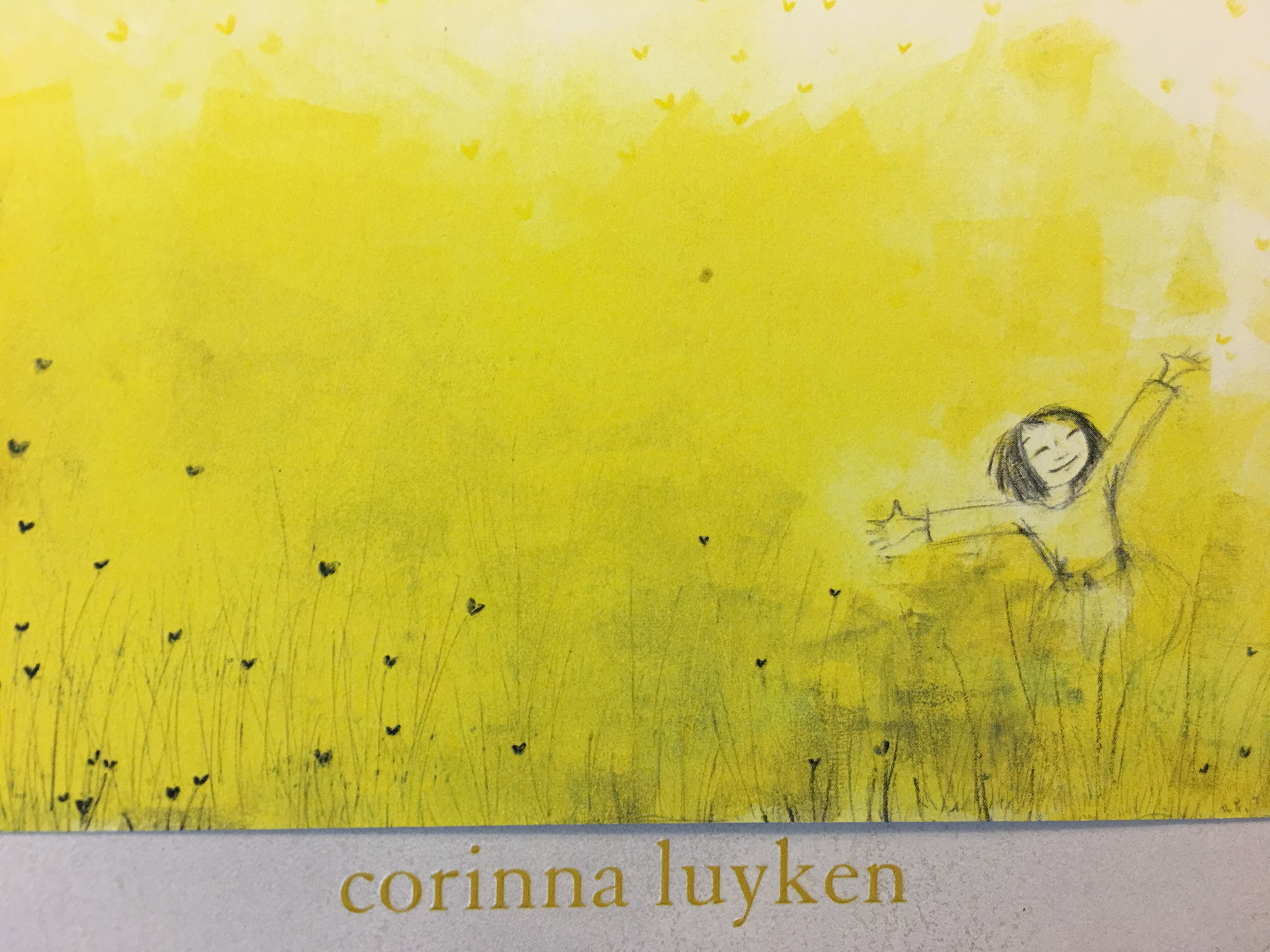 image of girl with arms open to the sky in a yellow field